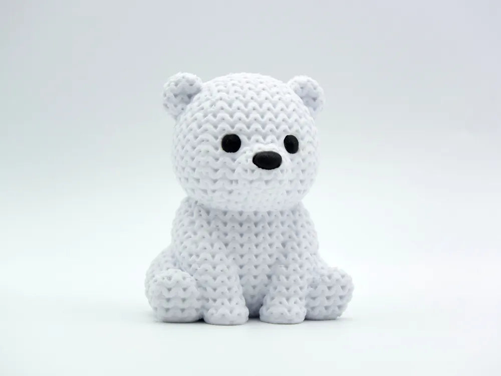 White knitted textured 3D printed baby polar bear figure/ key tag on a white background