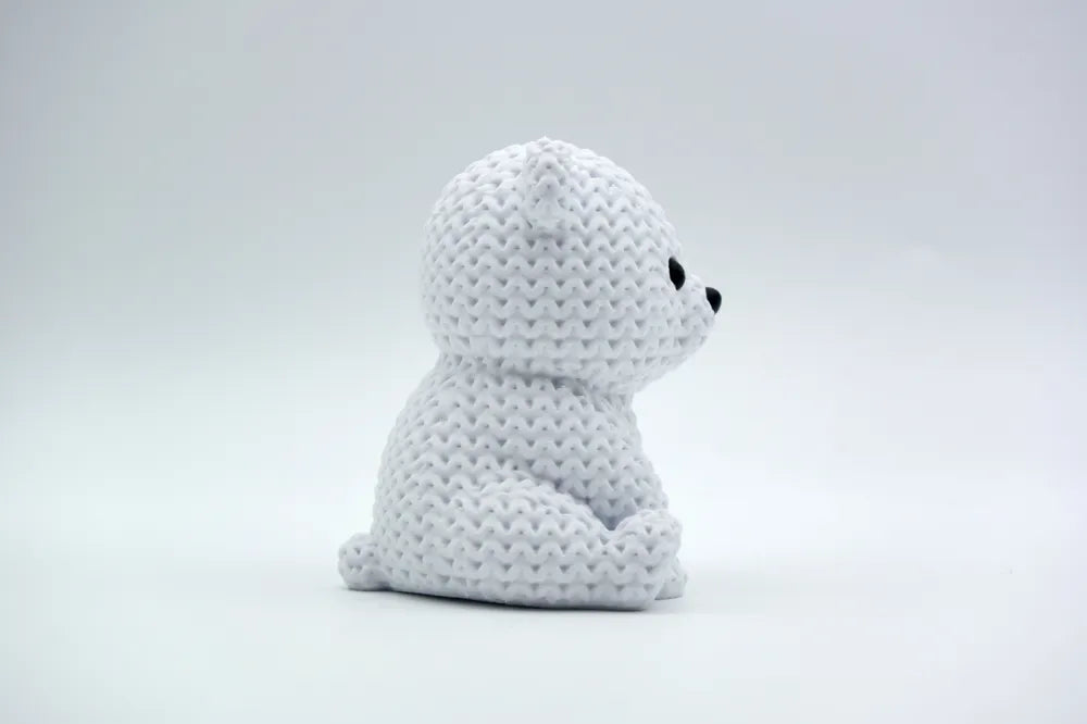 White knitted textured 3D printed baby polar bear figure/ key tag on a white background facing side ways