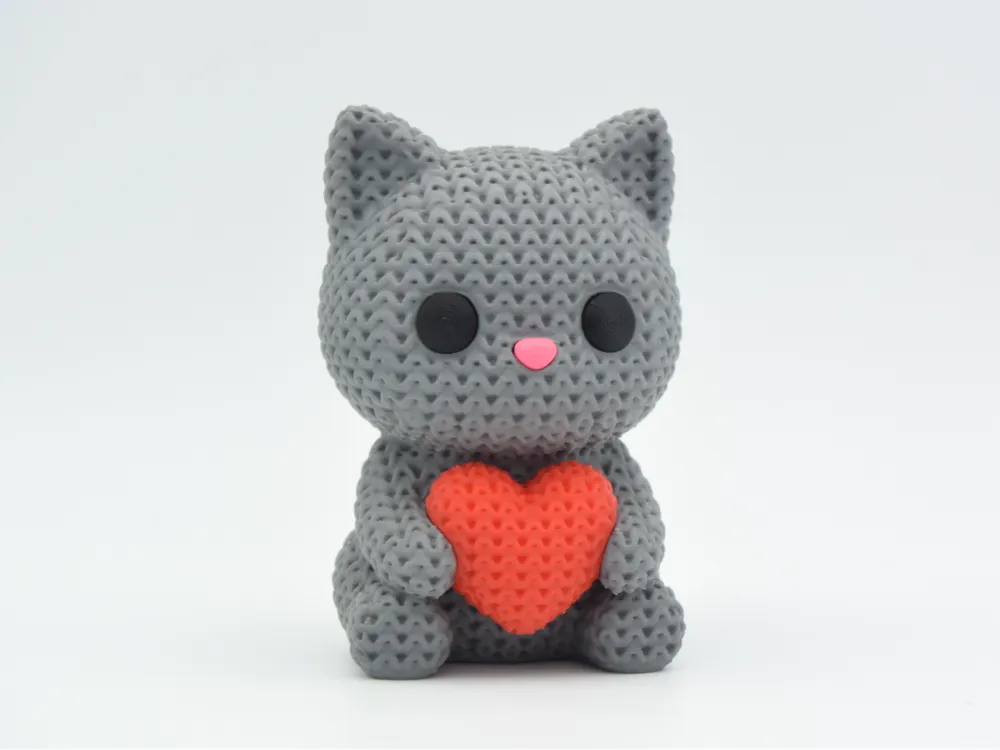 Grey coloured knitted textured 3D printed Cat with heart figure/ key tag on a white background