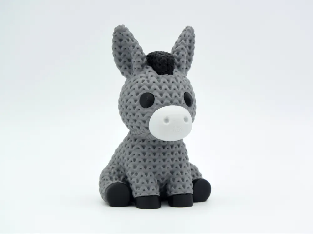 Grey coloured knitted textured 3D printed Donkey with heart figure/ key tag on a white background