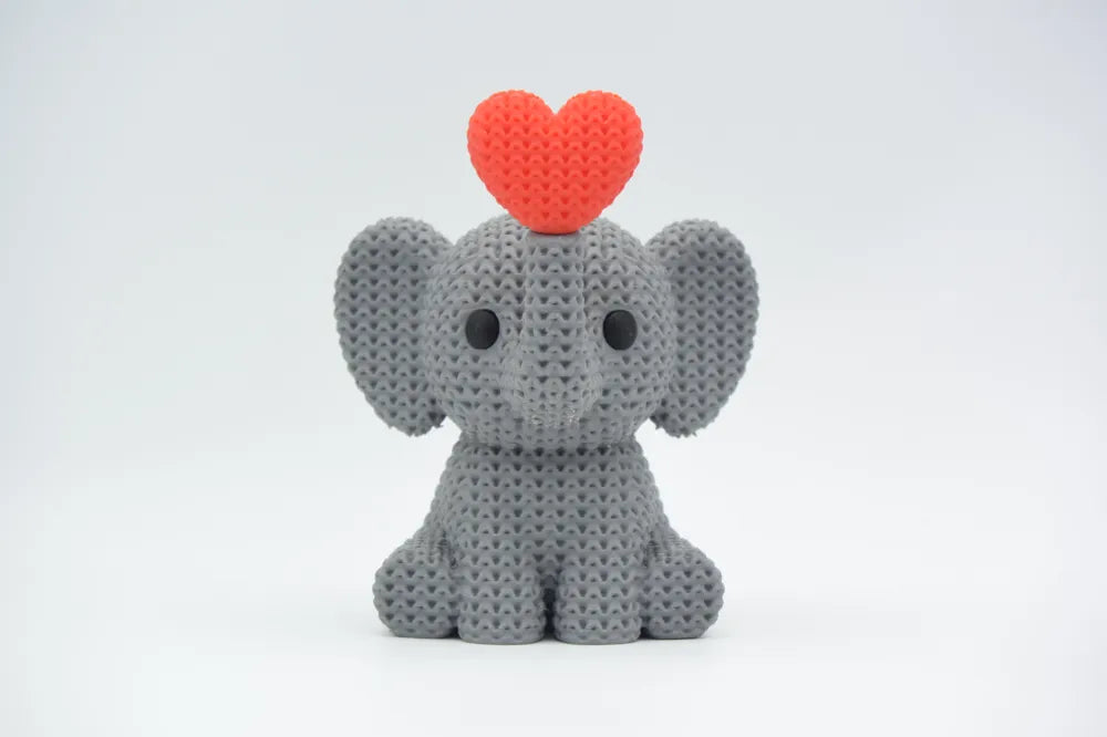Grey coloured knitted textured 3D printed Elephant with heart figure/ key tag on a white background facing forward