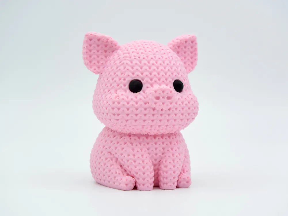 Pink knitted textured 3D printed pig figure/ key tag on a white background