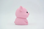 Pink knitted textured 3D printed pig figure/ key tag on a white background facing side ways