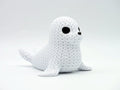 White knitted textured 3D printed seal figure/ key tag on a white background