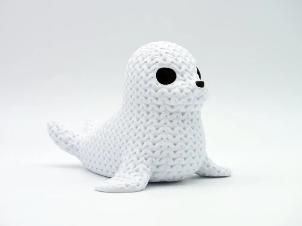White knitted textured 3D printed seal figure/ key tag on a white background