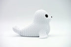 White knitted textured 3D printed seal figure/ key tag on a white background facing side ways