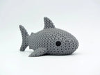 Grey knitted textured 3D printed shark figure/ key tag on a white background