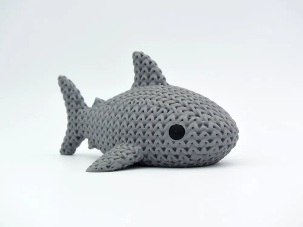 Grey knitted textured 3D printed shark figure/ key tag on a white background
