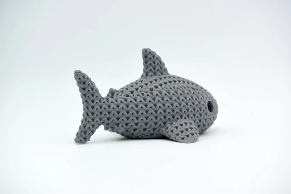 Grey knitted textured 3D printed Shark figure/ key tag on a white background facing side ways